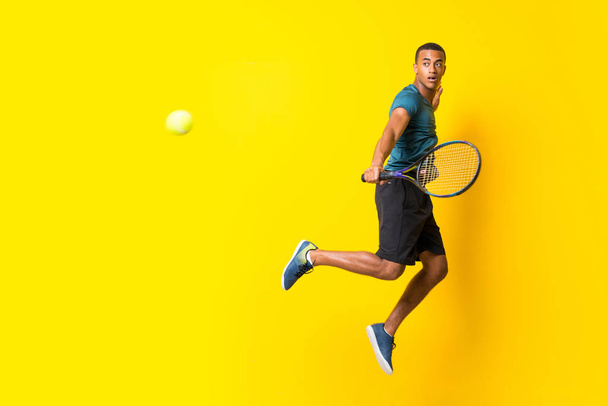 Afro American tennis player man over isolated yellow background - Photo, Image
