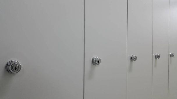 Vista panorámica de taquillas o armarios en fila con puertas blancas
 - Foto, Imagen