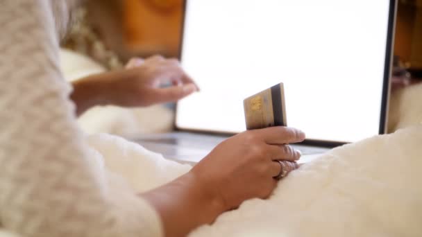 Zbliżenie materiału 4K młodej kobiety posiadając kartę kredytową w ręku podczas przeglądania intrnet i sklepów internetowych. Koncepcja shot zakupy online i e-commerce. - Materiał filmowy, wideo