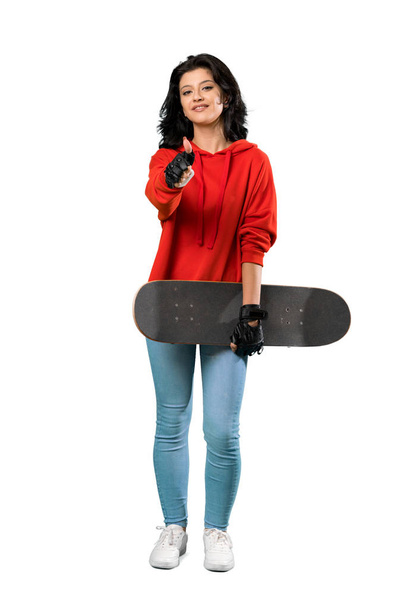 A full-length shot of a Young skater woman with thumbs up because something good has happened over isolated white background - Foto, Imagen