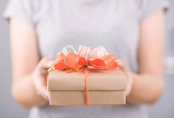 Женщина держит в руке подарочную коробку для подарков
 - Фото, изображение