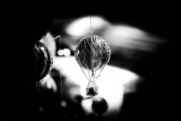 Hermoso bokeh de un pequeño juguete globo de aire caliente colgado en blanco y negro. - Foto, Imagen