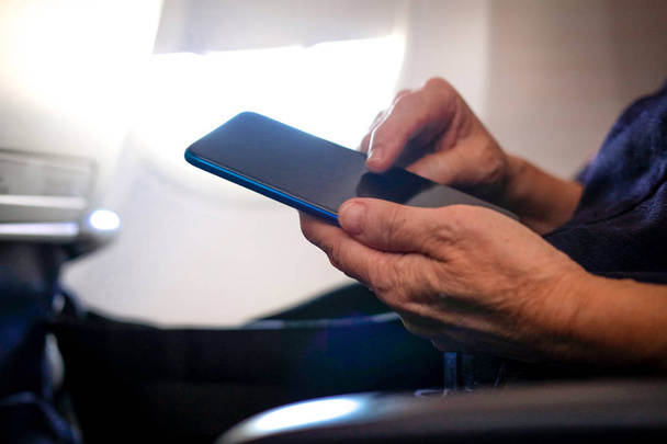 uçakta akıllı telefon kullanan kadın gezgin. yolcu tutma m - Fotoğraf, Görsel