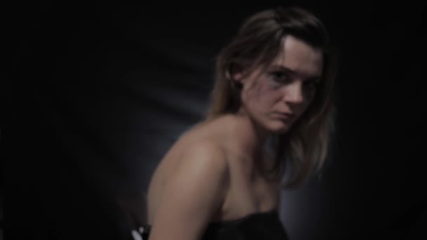 detener la violencia doméstica, la mujer con rímel untado en los ojos muestra el brazo con la frase No en primer plano habitación oscura
 - Metraje, vídeo