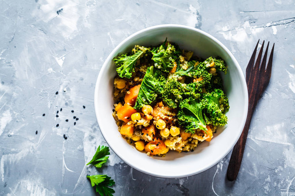 Vegan stew with chickpeas, sweet potato and kale in white bowl  - Photo, image