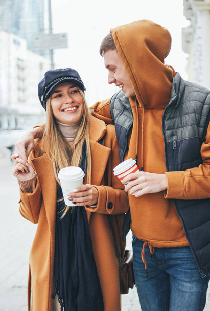 Happy young couple in love teenagers friends dressed in casual style walking together on city street in cold season - Fotografie, Obrázek