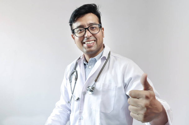 mužský indický lékař v bílém plášti a stetoskop s palci  - Fotografie, Obrázek