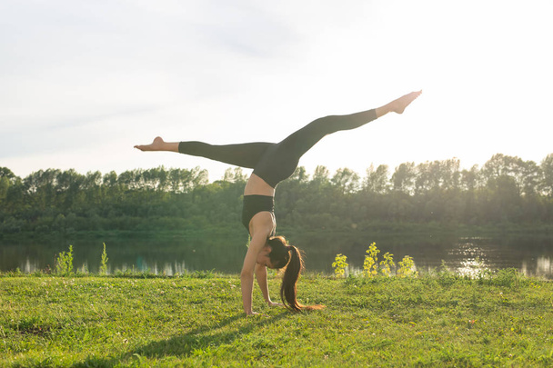 Mujer joven disfrutando de yoga relajante al aire libre en el parque
. - Foto, imagen