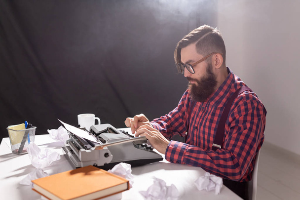 Koncepcja ludzi i technologii - pisarz siedzi przy stoliku otoczony skrawki papieru - Zdjęcie, obraz