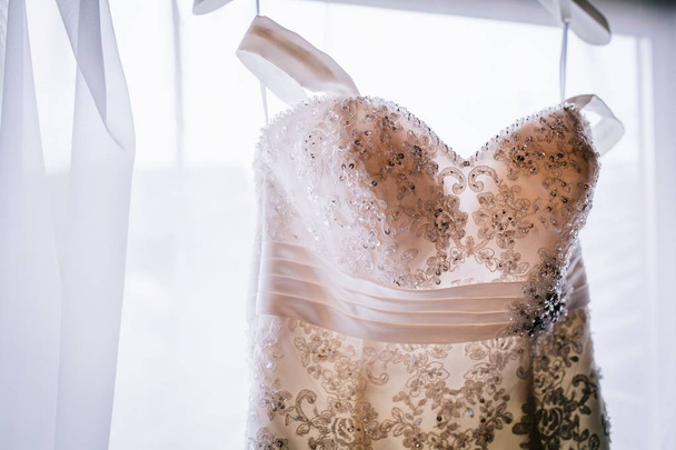 Close shot of the brides dress before the wedding with a blurred background - Фото, изображение