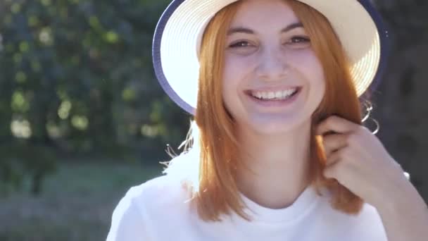 Kırmızı saçlı genç güzel kızın kamerada mutlu bir şekilde gülümseyen portresi. - Video, Çekim