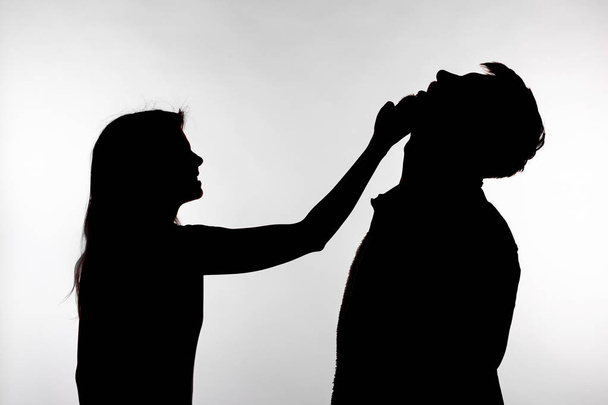 Aggression and abuse concept - man and woman expressing domestic violence in studio silhouette isolated on white background. - Фото, изображение