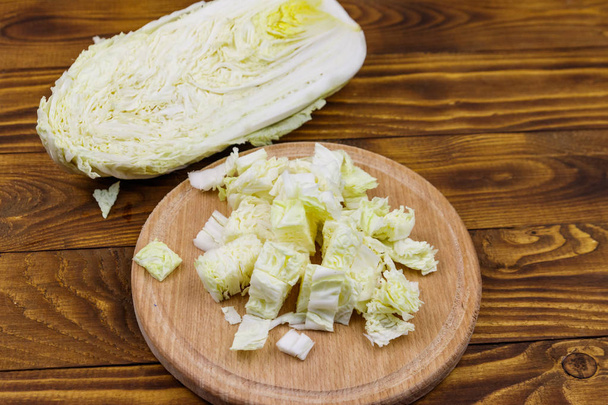 Chopped chinese cabbage on cutting board on wooden table - Fotografie, Obrázek