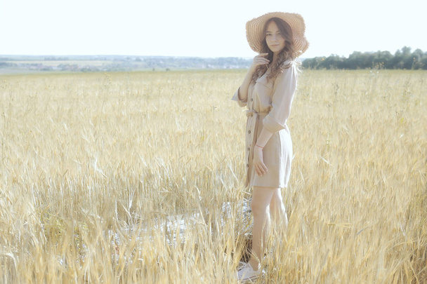 счастливая молодая взрослая модель в желтом пшеничном поле / летняя концепция счастья девушка в поле
 - Фото, изображение