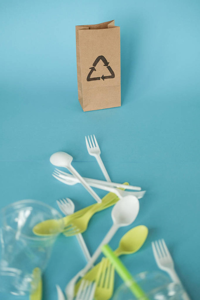plastic white spoons and green forks. blue background. the concept of ecology . paper as an alternative - Photo, image