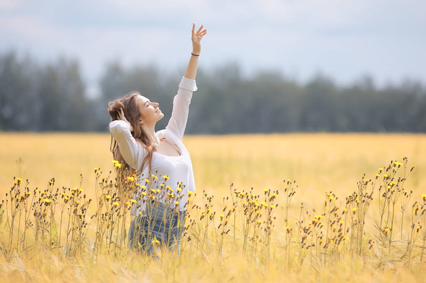 happy girl in autumn field with spikelets landscape / adult young girl portrait, summer look, nature - Photo, image