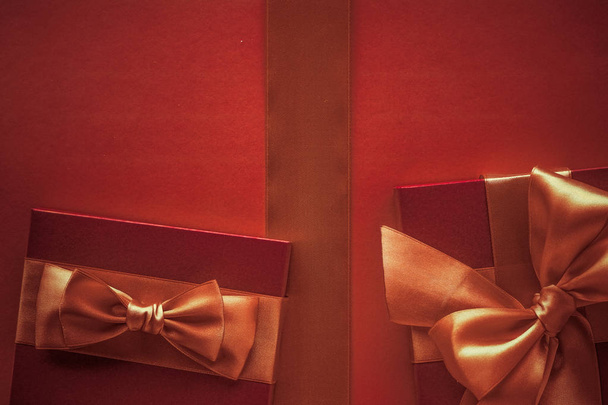 Πολυτελή δώρα με χρυσό τόξο ως φόντο διακοπών, Αγίου Βαλεντίνου D - Φωτογραφία, εικόνα
