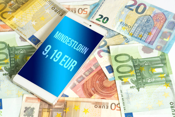 ドイツでの最低賃金である9,19ユーロを基準としたユーロ紙幣とスマートフォン - 写真・画像
