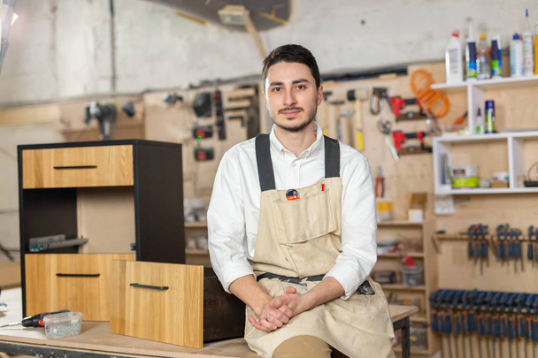 Мебельная фабрика, Концепция малых предприятий и людей - Портрет улыбающегося мужчины-рабочего на производстве
 - Фото, изображение