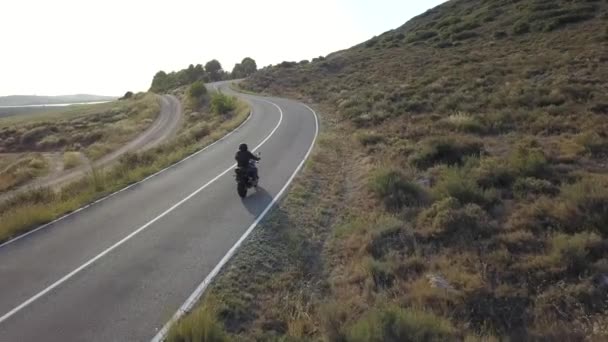 Vidéo du motocycliste conduisant sa moto sur la route de montagne à la campagne. Vue aérienne
. - Séquence, vidéo