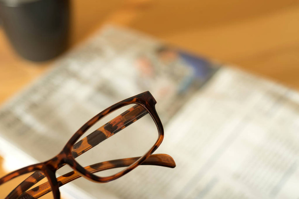 Een leesbril en een krant - Foto, afbeelding