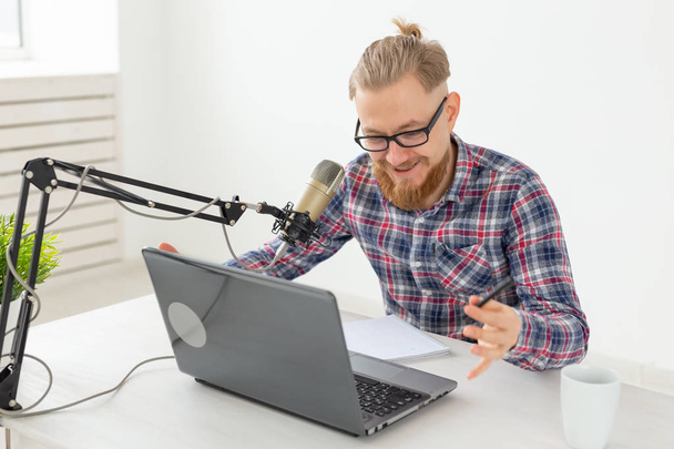 Radiomoderator, Streamer und Blogger-Konzept - gutaussehender Mann, der als Radiomoderator bei einem Radiosender vor dem Mikrofon sitzt - Foto, Bild
