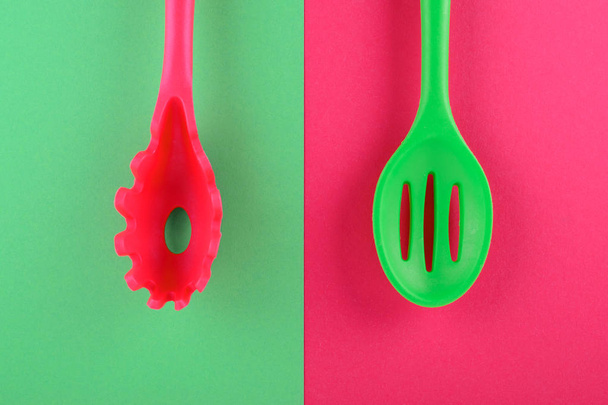 bright kitchen utensils on red and green background, creative idea - Фото, изображение