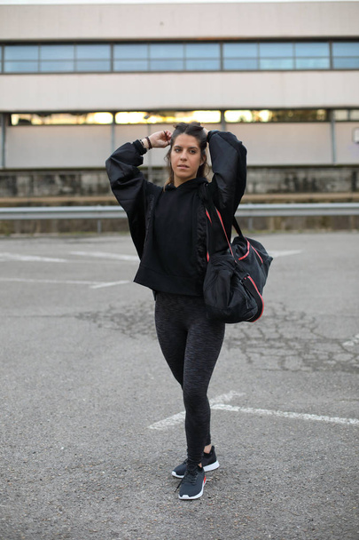 Sporty young woman getting ready for urban fitness workout - Zdjęcie, obraz