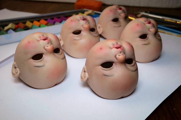 Making dolls. Heads of dolls are on the table by artist doll mas - Photo, Image