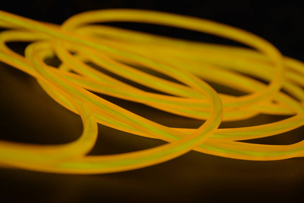 Zářivý oranžový světelný drát, kroucený světelný drát, kabel. Různé tvary a obrázky lektorských drátů s různými větvičmi, šťavnatý drát. - Fotografie, Obrázek