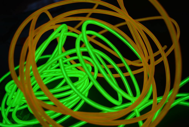 Яскраві яскраво-жовті і зелені, лайм неонові дроти в різних форматах і компонуваннях. Електролюмінесцентний провід, неонове світлове керівництво, льодова трубка складаються в різні структури і форми
. - Фото, зображення