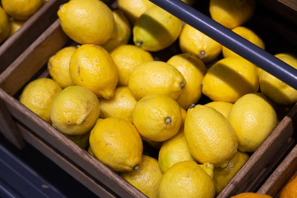 Muchas cajas de madera con limones amarillos frescos y brigh ricos en vitaminas
 - Foto, Imagen