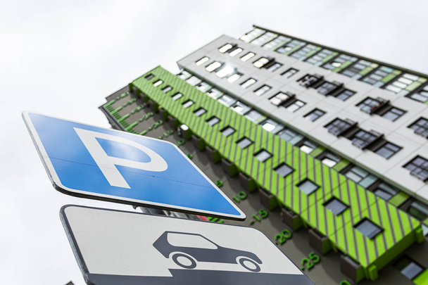 Bodenansicht der Straßenbeschilderung Vorfahrt für parkendes Fahrzeug gegen modernen, frisch gestrichenen Wohnblock. Foto mit Schärfentiefe - Foto, Bild