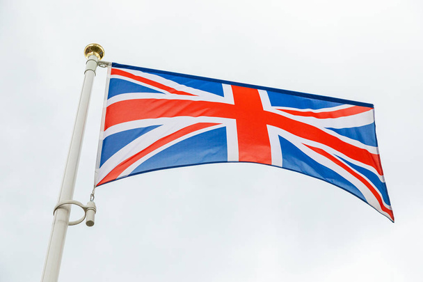 Rüzgarda gökyüzüne karşı sallanan İngiliz bayrağı - Fotoğraf, Görsel