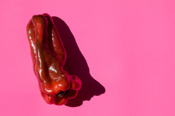 Grote peper met schaduw op een roze achtergrond - Foto, afbeelding