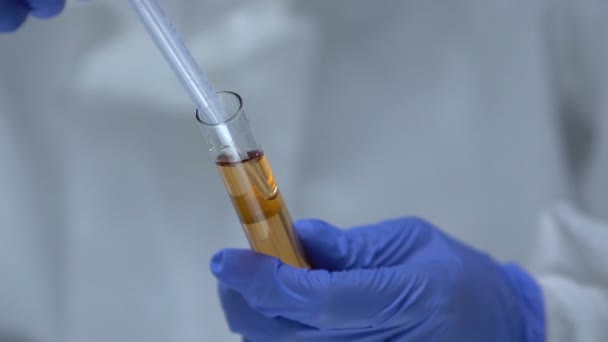 Chemist in protective uniform taking toxic liquid sample from test-tube, danger - Video, Çekim