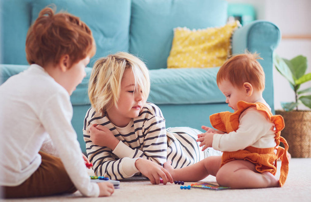 cute kids, siblings playing together on the floor at home - 写真・画像