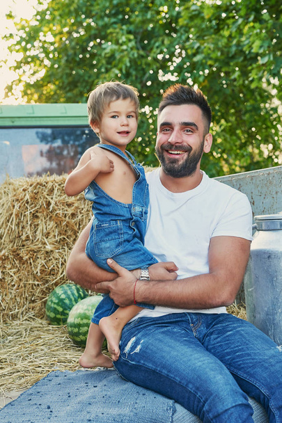 Raccolta di angurie, padre con figlio vicino a un pick-up in estate al tramonto
 - Foto, immagini