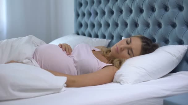 Pregnant woman feeling unwell lying in bed, sleep disorder, health problems - Filmati, video