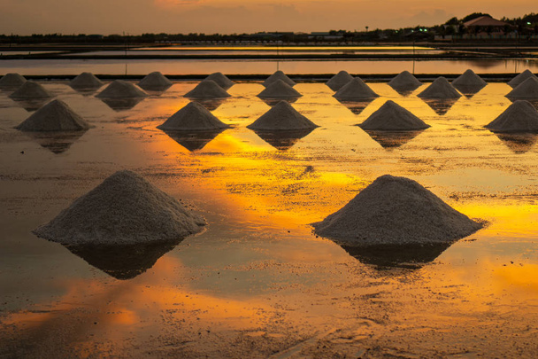 Tuz tarlalarında akşam saatlerinde tuz, depoya taşınmadan önce tuz ların yığına itilmesi sırasında. - Fotoğraf, Görsel