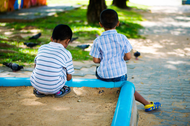 backview two boys sitting in playground - Foto, Bild