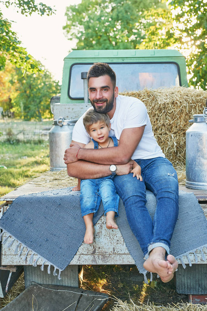 Cosechando sandías, padre con hijo cerca de una camioneta en verano al atardecer
 - Foto, imagen