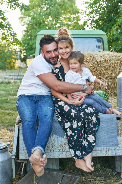 family with watermelons at the harvest next to a pickup truck in summer at sunset - Φωτογραφία, εικόνα