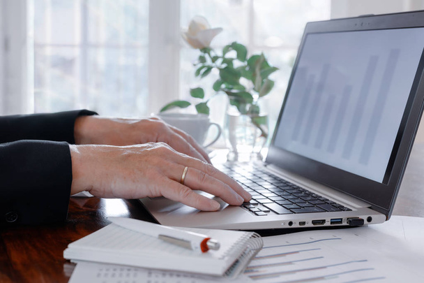 zakenvrouw werkt aan een laptop op kantoor om financiën en belastingen te berekenen - Foto, afbeelding