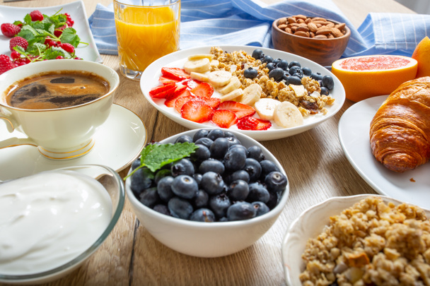 Café da manhã saudável servido com prato de iogurte muesli mirtilos morangos e banana
. - Foto, Imagem