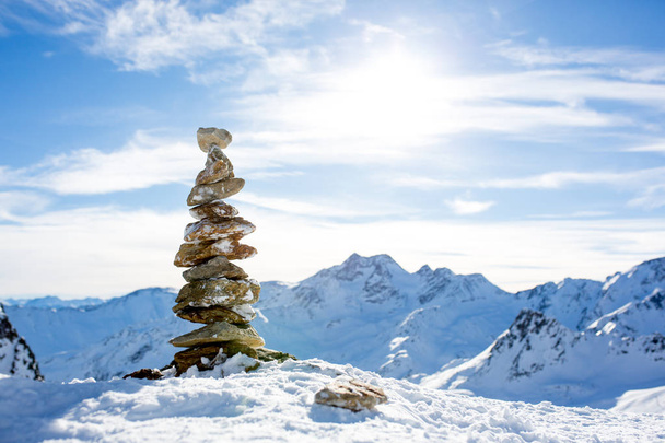 Pile of rocks on top of the mountain on sunset, snow and blue sk - Фото, зображення