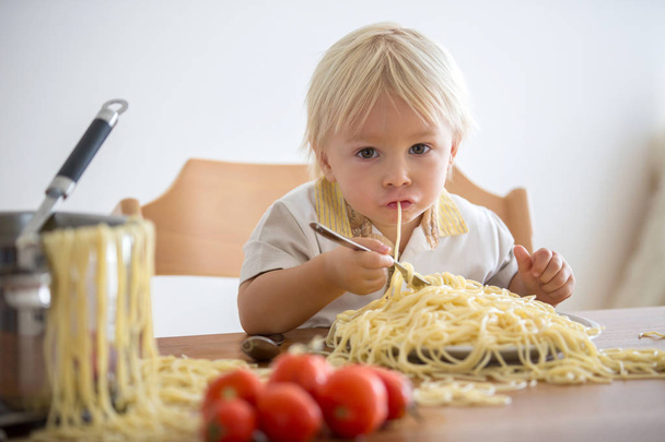 Little baby boy, toddler child, eating spaghetti for lunch and m - Foto, immagini