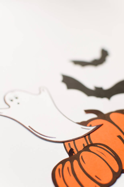 Decoraciones de Halloween con calabazas de papel, murciélagos, velas sobre fondo blanco. Halloween y concepto de decoración. Plano, vista superior, espacio para copiar
 - Foto, imagen