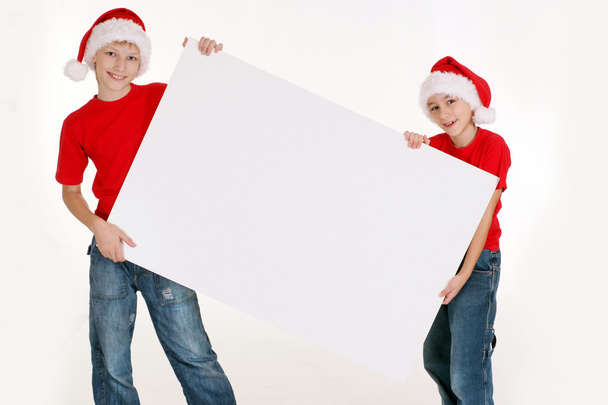 kids in santa hats with board - Foto, imagen