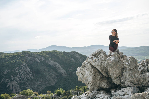 Girl sitting on top of a mountain - Φωτογραφία, εικόνα